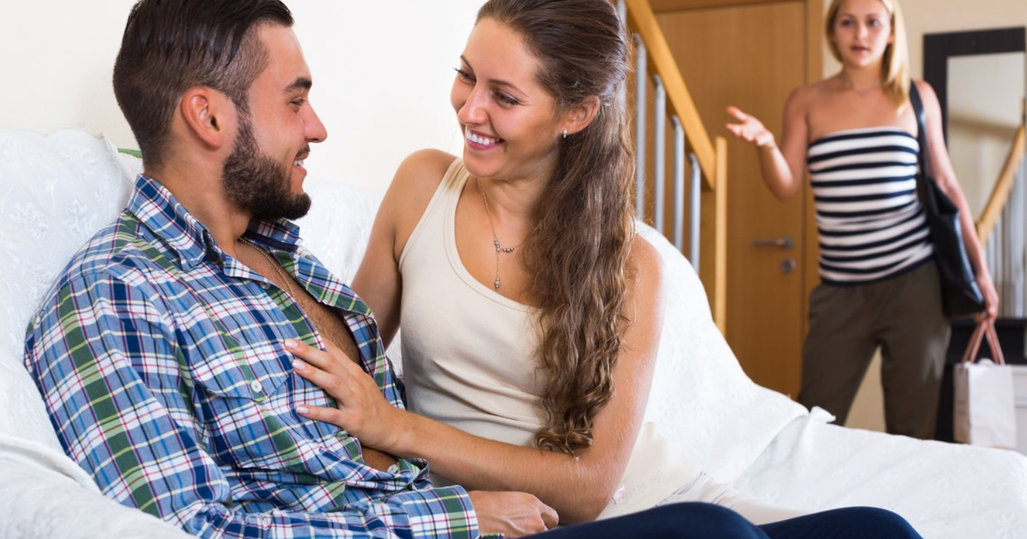 A man flirting with a woman in front of his partner.